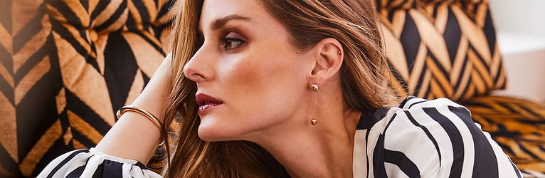 Olivia Palermo arborant des bracelets joncs en or et diamants et des boucles d’oreilles de luxe
