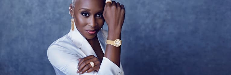 Cynthia Erivo wearing rose gold diamond jewelry and a gold diamond watch