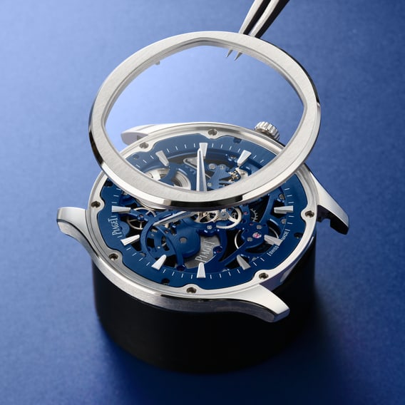 Close-up of a Piaget Polo watch bezel on a blue background.