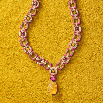 gold sautoir watch with precious gemstone assembly.
