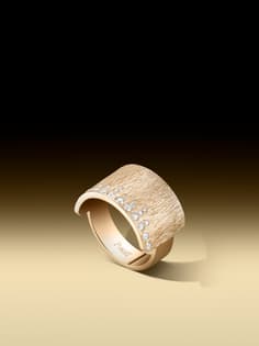 Piaget Glow Ring aus Roségold mit einem breiten, strukturierten und gebürsteten Band, das auf seiner Oberfläche mit funkelnden Diamanten besetzt ist.