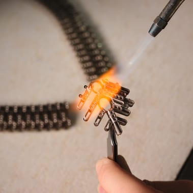 Heating the metal frame of a sautoir necklace for precious gemstone assembly