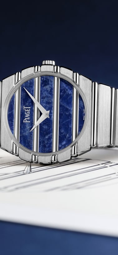 Piaget Uhr mit blauem Sodalith-Zifferblatt und silbernem, integriertem Metallarmband, platziert auf einer Uhrenskizze auf einer weißen Oberfläche vor einem dunkelblauen Hintergrund.